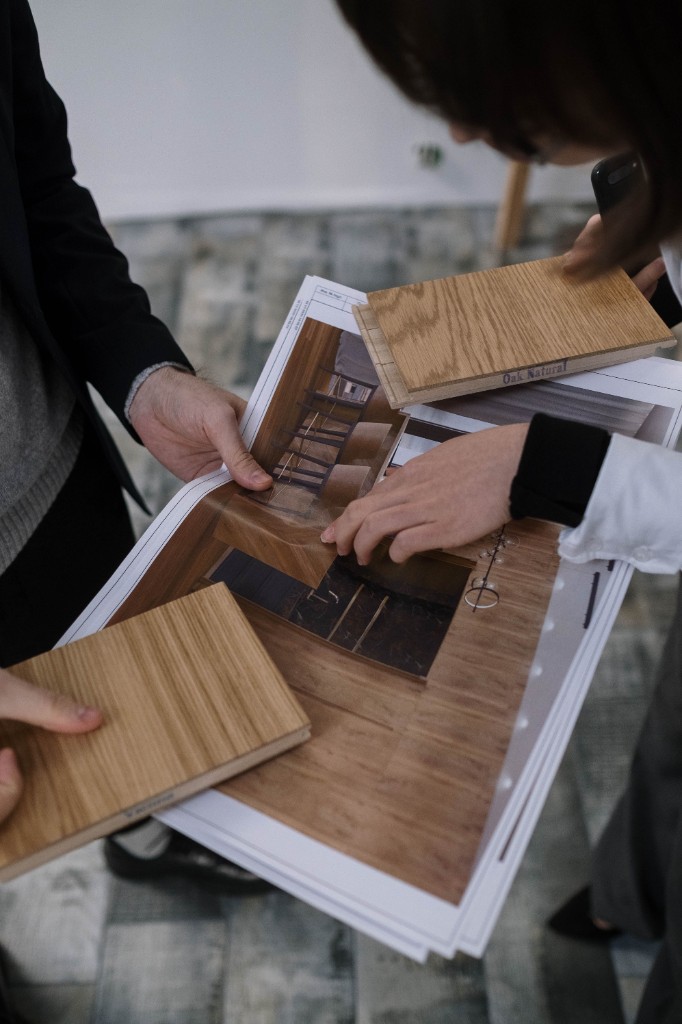 Designers reviewing plans, renderings, and oak samples