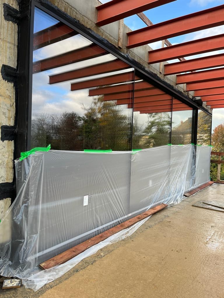 Large-format glazing install with protective film on site